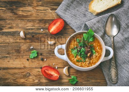 kharcho soup from rice beef tomatoes spicy herbs in white bowl piece of bread canvas cloth on old wooden table traditional Georgian cuisine