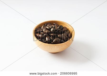 Isolate coffee beans on wooden bowl on white background, Raw and freshness.Closed up.