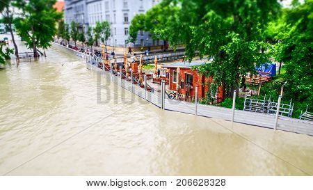 extreme floods in Europe with ordinary life behind flood-protection barriers in tilt shift view