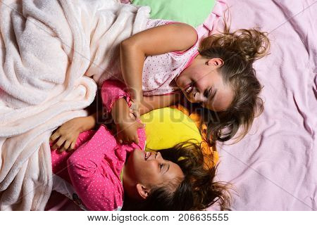 Schoolgirls In Pink Pajamas Wallow On Colorful Pillows, Top View