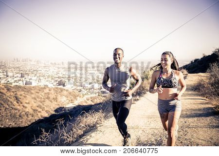 Multi-ethnic couple training in a canyon - Sportive boyfriend and girlfriend running outdoors