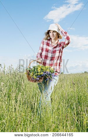 Girl With A Basket Of Flowers In The Field.