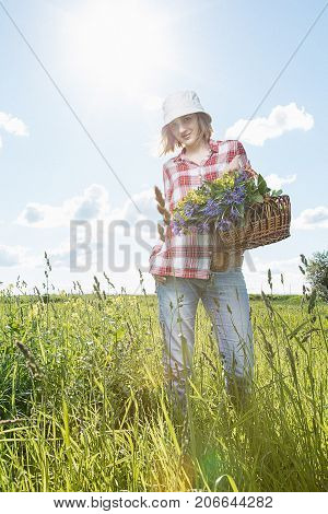 Girl With A Basket Of Flowers In The Field.