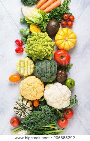 Overhead table top view colorful rainbow vegetables on the light grey background, copy space for text below, selective focus