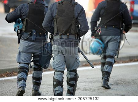 Three Policemen With Anti-bulletproof Jacket In Anti-riot Unifor