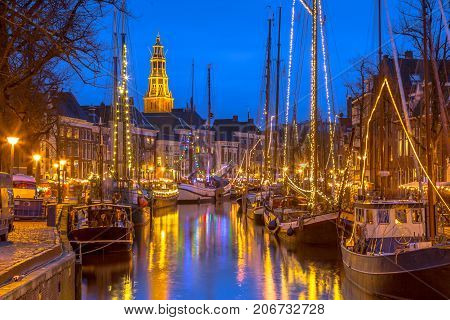 Historic sailing ships moored at river quay on the annual Winterwelvaart festival around christmas. Reliving the old times in the historic part of Groningen city.