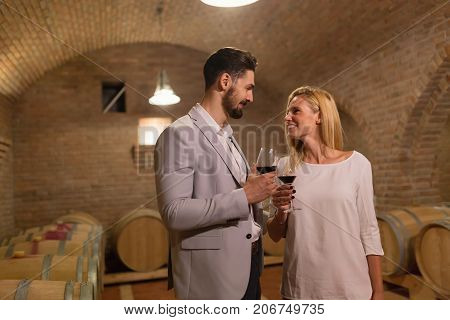 Wine loving couple tasting wines in winery cellar