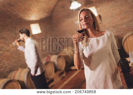 Wine loving couple tasting wines in winery cellar