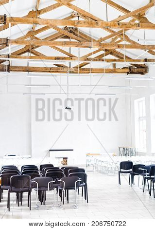 Wooden Roof Structure in White Bright Interior. Old Rafters in the Loft Interior