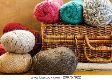 Vintage Crafts Wicker Chest Box Clews Balls of Colorful Wool Yarn Red Blue White Beige Grey Knitting Hobby Header Banner for Websites Close up