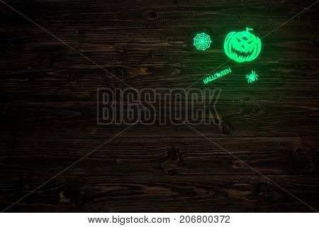 Halloween Glowing Phosphoric Jack-o'-lantern Over Wooden Table Background. Neon Light