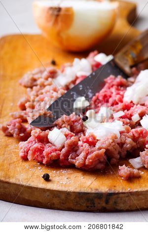 Force meat with onion on the cutting board .style rustic .selective focus