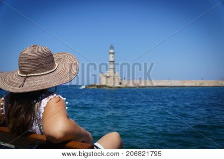 woman in front of the lighthouse from chania with blue sky