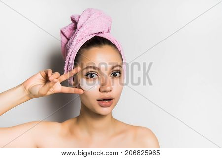 cute girl with a pink towel on her head looking at the camera, isolated