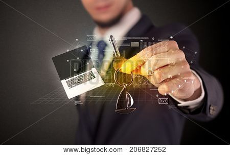 Businessman in suit holding keys with statistics, graphs and icons around