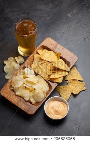 Beer In Glasses Closeup On The Concrete Table. Beer And Snacks Are Chips And Nachos With Cheese Souc