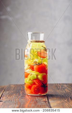 Water Flavored with Cherry Tomato and Celery Stems. Vertical Orientation.