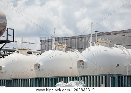 Field filled with silver industrial propane tanks.