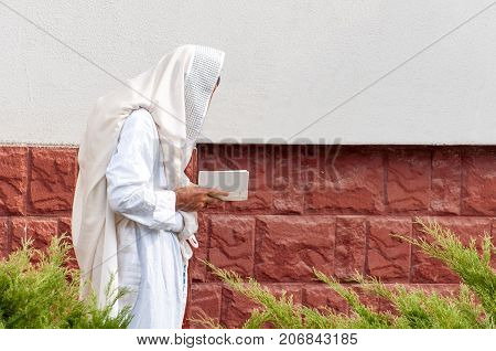 Orthodox hassidic Jew pray in a holiday robe and tallith.