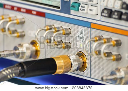 Measuring high-frequency equipment. Special high-frequency connectors are inserted into the instrument panel. Abstract industrial background.