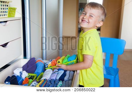 The Child Puts His Clothes On. The Boy Pulls The T-shirt Out Of The Closet.