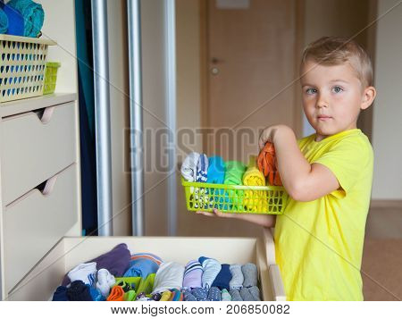 The Child Helps My Mother. The Boy Puts The T-shirts In A Drawer.