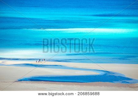 View of the amazing beach of Balos, with a family playing on the tropical sandy beach with turquoise waters, Crete, Greece