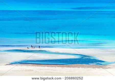 View of the amazing beach of Balos, with a family playing on the tropical sandy beach with turquoise waters, Crete, Greece