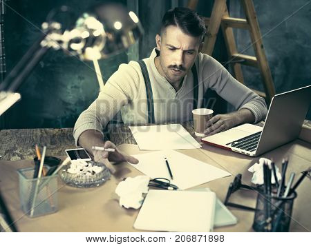 The Handsome Elegant Man Sitting At Home Table, Working And Usin
