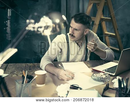 The Handsome Elegant Man Sitting At Home Table, Working And Usin