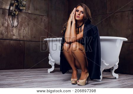 pretty young girl sits on the bathtub