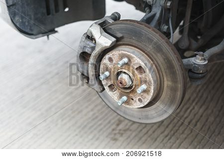Detail of disc brake system of a car without the wheel to recap the tire.