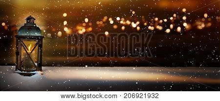 Burning lantern in a winter landscape with golden bokeh in the christmas night