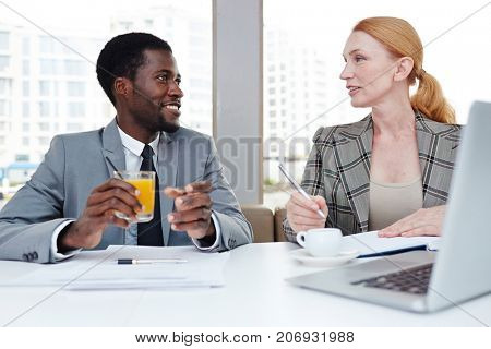 Intercultural colleagues communicating by drink during business travel