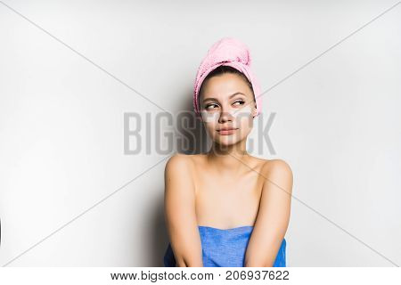pensive girl with a towel tied around her head with a mask on her face