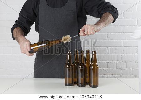 Homebrewing: craft beer brewer cleaning empty beer bottles.