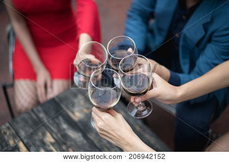 Young People Holding Glass Talk In The Party.