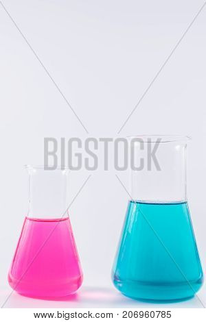 research, science and clinic background. 96 well micro plate and  laboratory beakers with colorful liquids and reagents.