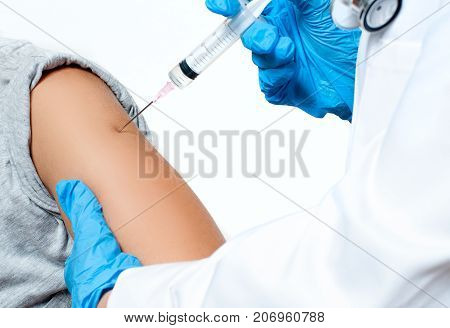 Vaccination. Doctor injecting flu vaccine to patient's arm. Doctor making woman an injection