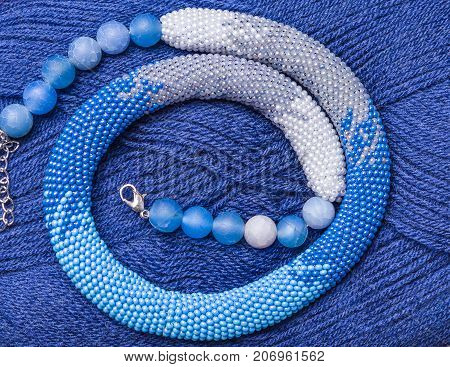 knitted flagellum from beads on a background of blue threads