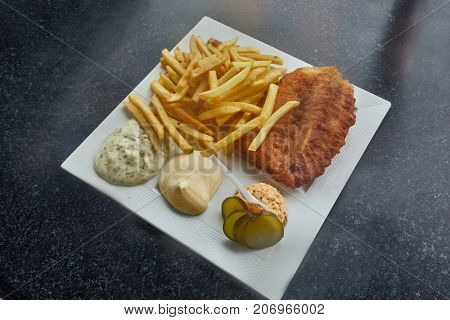 Fish and Chips served with sauces and salmon salad