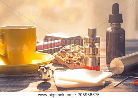 Still Life With Electronic Cigarette With Botle And Coffe On The Wooden Background