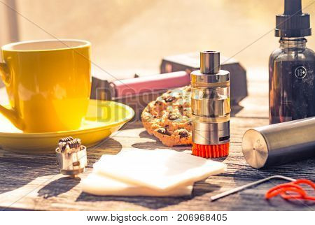 Still Life With Electronic Cigarette With Botle And Coffe On The Wooden Background
