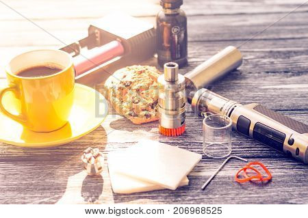 Still Life With Electronic Cigarette With Botle And Coffe On The Wooden Background