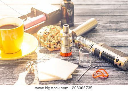 Still Life With Electronic Cigarette With Botle And Coffe On The Wooden Background