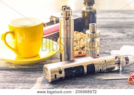 Still Life With Electronic Cigarette With Botle And Coffe On The Wooden Background