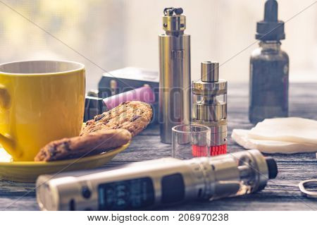 Still Life With Electronic Cigarette With Botle And Coffe On The Wooden Background