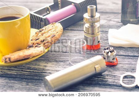 Still Life With Electronic Cigarette With Botle And Coffe On The Wooden Background