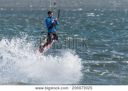 WALVIS BAY NAMIBIA - JULY 2 2017: An unidentified kite surfer airborne at the lagoon at Walvis Bay in the Namib Desert on the Atlantic Coast of Namibia