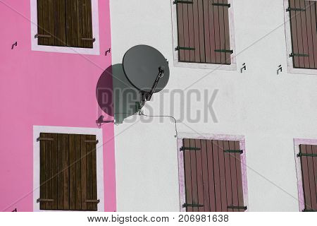 satellite dish to receive satellite TV programs on the wall of an house
